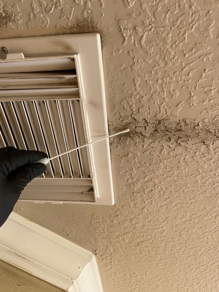 TDLR-licensed mold inspector taking an air sample near a bathroom ceiling in Houston