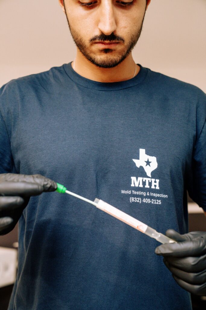 MTH technician transferring a swab sample into a labeled collection tube for accredited lab analysis