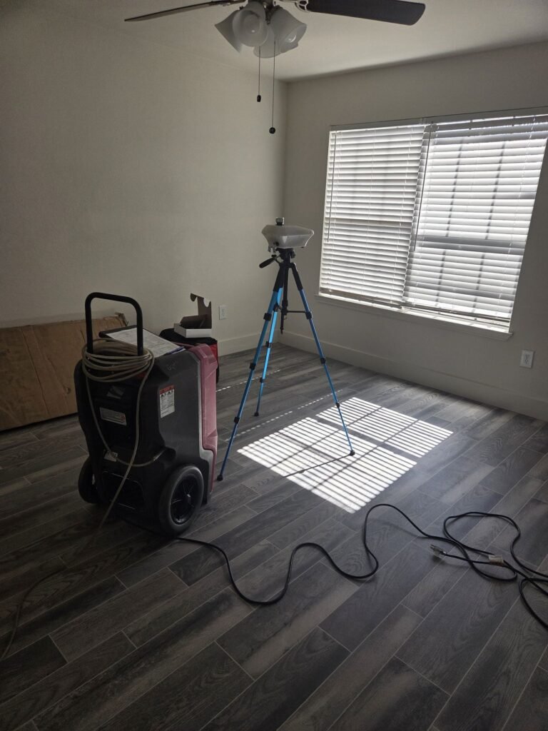 Drying equipment and air sampling gear set up in a water damaged apartment