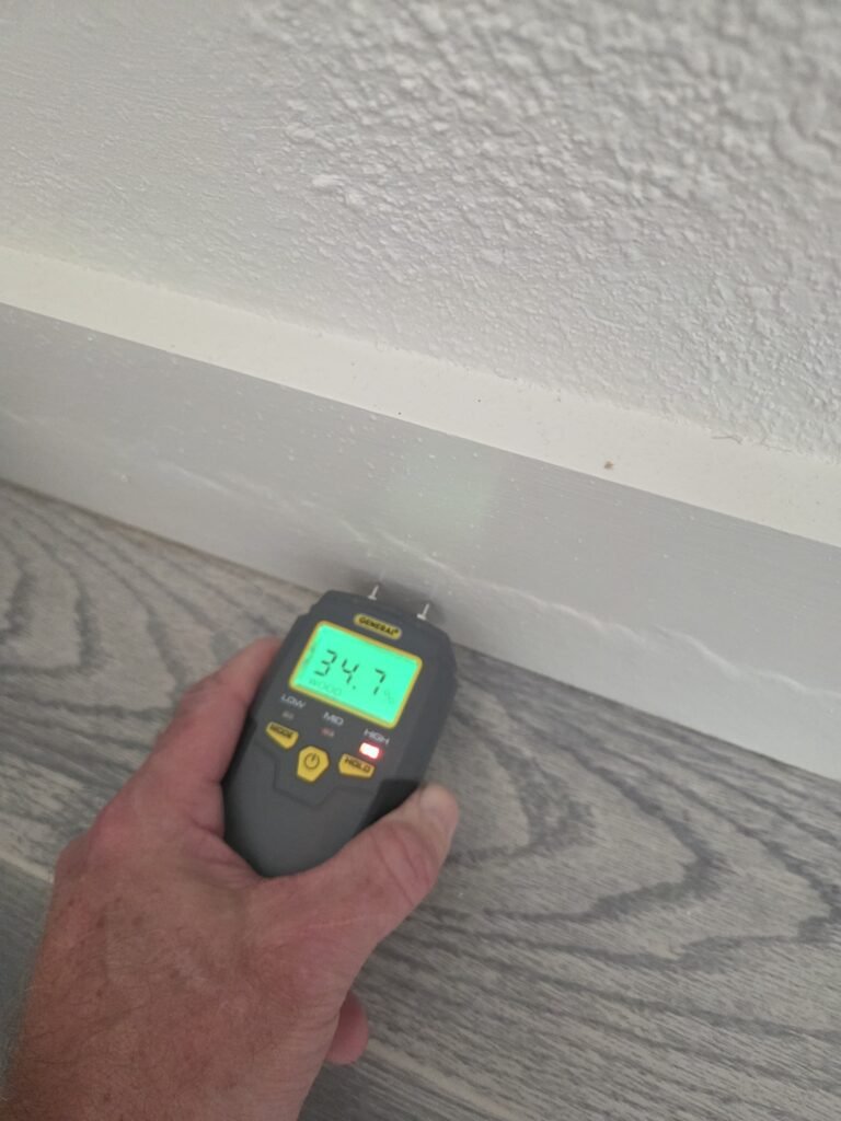 Moisture meter reading taken at a baseboard in a Katy apartment