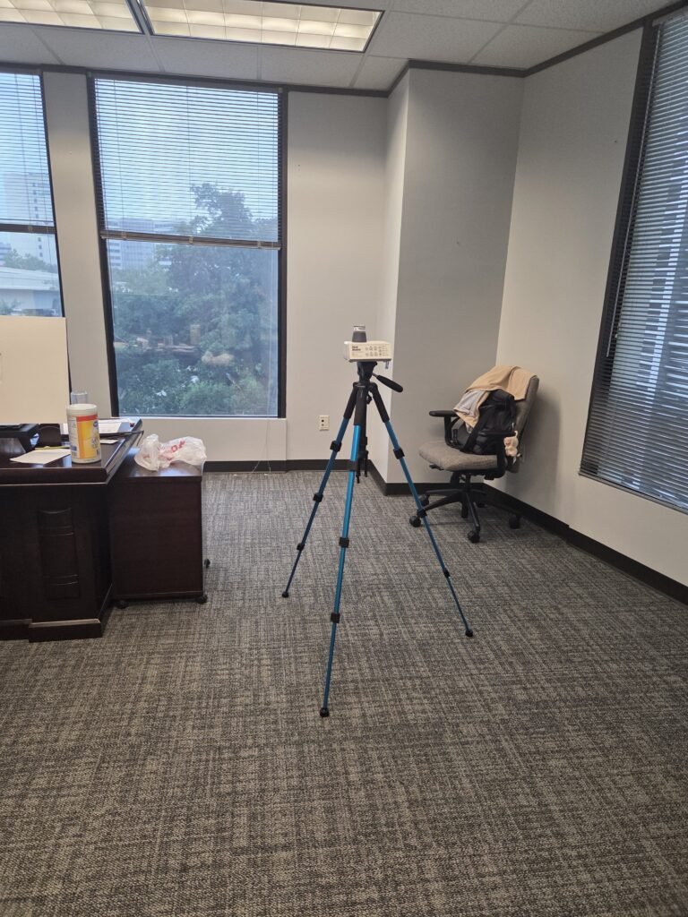 Air sampling pump on a tripod beside a window in an Uptown office